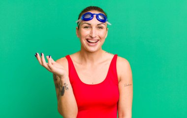 young pretty woman feeling happy, surprised realizing a solution or idea. swimmer concept