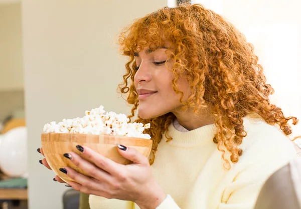 Young Red Hair Latin Pretty Woman Eating Popcorns Couch Watching — Stockfoto