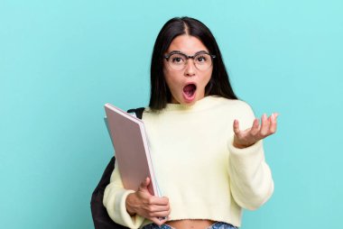 hispanic pretty woman feeling extremely shocked and surprised. university student concept