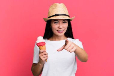 hispanic pretty woman pointing at camera choosing you. ice cream and summer concept