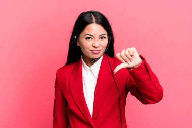 Latin kökenli güzel bir kadın kızmış, baş parmağını kaldırmış. tele pazarlama kavramı