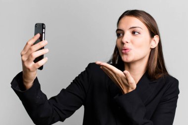 Genç ve güzel iş kadını akıllı telefonunu kullanıyor.