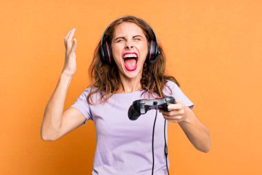 hispanic pretty young woman playing with headphones and a control. gamer concept