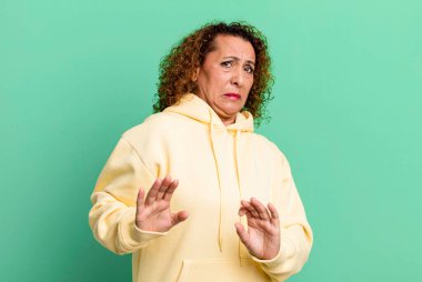 Orta yaşlı İspanyol kadın iğreniyor ve midesi bulanıyor. Pis kokan ya da kötü kokan bir şeyden kaçıyor.