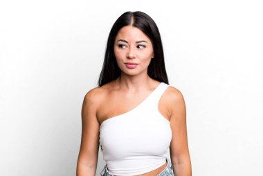 Güzel Latin kadın merak ediyor, mutlu düşünceler ve fikirler düşünüyor, hayal kuruyor, kenarda yer arıyor.