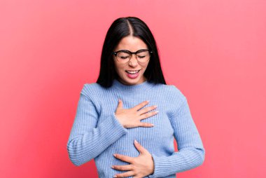 Güzel Latin bir kadın komik bir şakaya yüksek sesle gülüyor, mutlu ve neşeli hissediyor, eğleniyor.