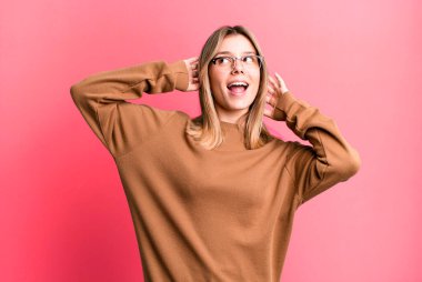 Güzel sarışın kadın gülümsüyor ve rahatlıyor, tatmin oluyor ve kaygısız, neşeli ve rahatlatıcı.