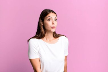 Güzel, genç, yetişkin bir kadın. Aptal, çılgın, şaşırmış bir yüz ifadesi var. Yanakları şişmiş, doldurulmuş, şişman ve yemek dolu.