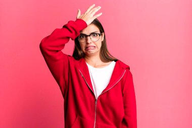 pretty young adult woman raising palm to forehead thinking oops, after making a stupid mistake or remembering, feeling dumb