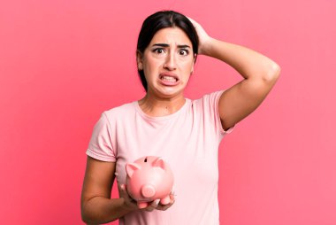 Stresli, endişeli ya da korkmuş hissediyorum, ellerim başımda. Domuz kumbarasıyla.