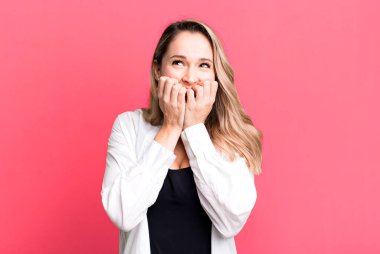 Endişeli, endişeli, stresli ve korkmuş görünüyor, tırnaklarını yiyor ve yanal kopya alanı arıyor.