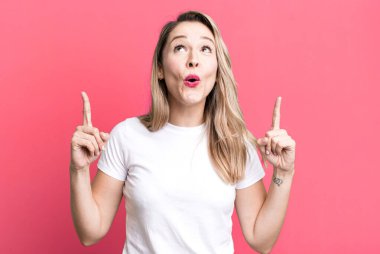 Şaşırmış, şaşırmış ve ağzı açık bir şekilde iki eliyle uzayı kopyalamak için yukarı bakıyor.