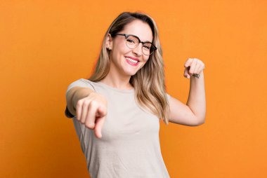 Mutlu ve kendinden emin hissetmek, kameraya iki elinle işaret etmek ve gülmek, seni seçmek.