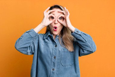 Şaşırmış, şaşırmış ve şaşırmış hissediyorum, şaşkın ve inanmayan bir bakışla gözlük tutuyor.