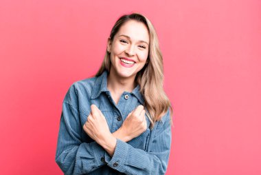 Neşeli bir şekilde gülümseyen ve kutlayan, yumruklarını sıkan, kollarını kavuşturan, mutlu ve pozitif hisseden