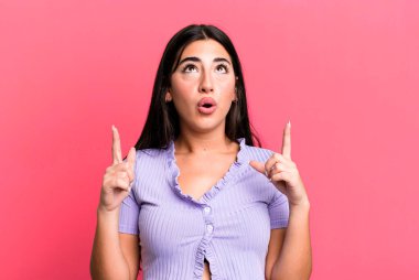 Şaşırmış, şaşırmış ve ağzı açık bir şekilde iki eliyle uzayı kopyalamak için yukarı bakıyor.