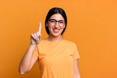 Gülümsüyor ve dost canlısı görünüyor, bir numara veya ilk eli önde, geriye doğru sayıyor.