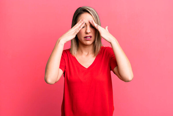 блондинка взрослая женщина выглядит напряженной и расстроенной, работает под давлением с головной болью и обеспокоена проблемами