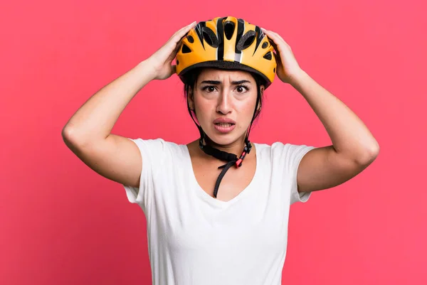 feeling stressed, anxious or scared, with hands on head. bike helmet concept