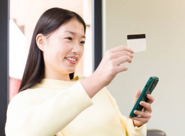 asian pretty woman using a smartphone and shopping at home