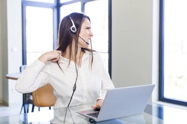 Genç ve güzel bir kadın stresli, endişeli, yorgun ve hayal kırıklığına uğramış hissediyor. tele pazarlamacı kavramı