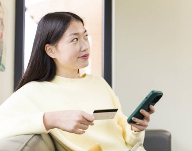 asian pretty woman using a smartphone and shopping at home