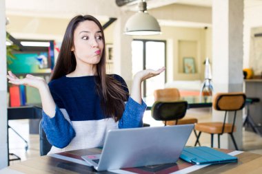 young pretty woman feeling puzzled and confused and doubting. telecommuting concept