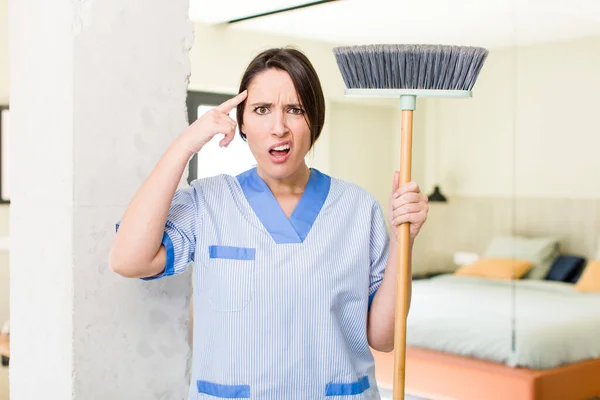 Young Pretty Woman Feeling Confused Puzzled Showing You Insane Housekeeper — Stock Photo, Image