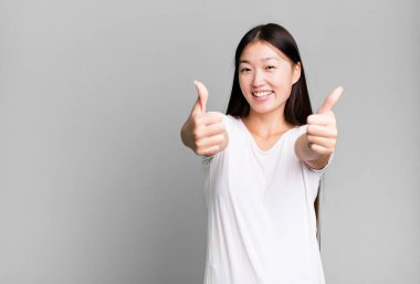 Genç, güzel, Asyalı, etkileyici bir kadın. Yanında fotokopi odası var.