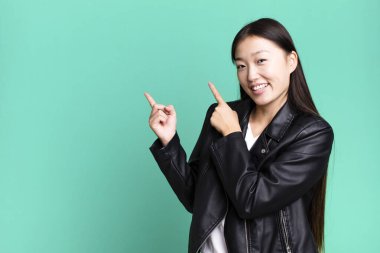 Genç, güzel, Asyalı, etkileyici bir kadın. Yanında fotokopi odası var.