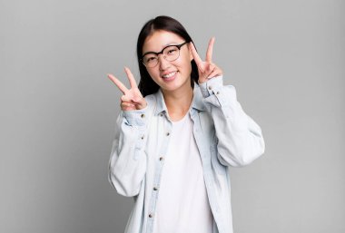 Genç, güzel, Asyalı, etkileyici bir kadın. Yanında fotokopi odası var.