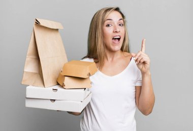 pretty blonde woman feeling like a happy and excited genius after realizing an idea. delivery take away food packages concept