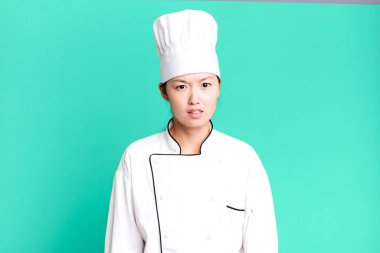 pretty asian woman feeling puzzled and confused. restaurant chef concept