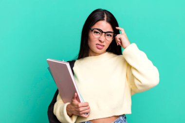 hispanic pretty woman feeling confused and puzzled, showing you are insane. university student concept