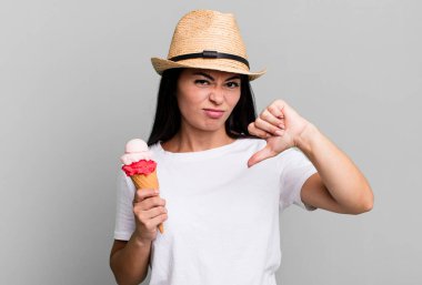 hispanic pretty woman feeling cross,showing thumbs down. ice cream and summer concept