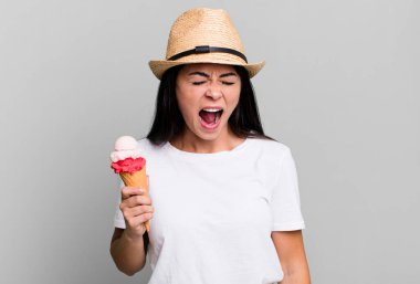 hispanic pretty woman shouting aggressively, looking very angry. ice cream and summer concept