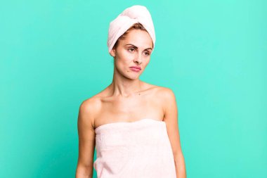 hispanic pretty woman feeling sad, upset or angry and looking to the side wearing pbathrobe. beauty concept