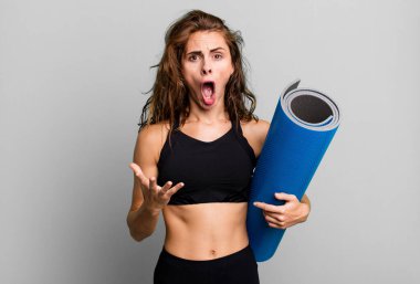 İspanyol güzel kadın inanılmaz bir sürprizle şaşkın, şaşkın ve şaşkın. fitness ve yoga konsepti