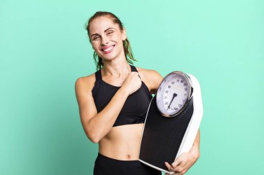 hispanic pretty woman feeling happy and facing a challenge or celebrating. fitness, diet and weight scale concept