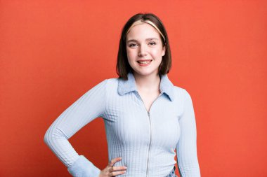 Genç ve güzel bir kadın mutlu bir şekilde gülümsüyor.