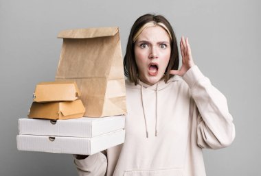 young pretty woman screaming with hands up in the air. take away fast food concept