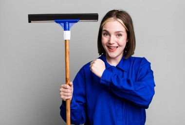 young pretty woman feeling happy and facing a challenge or celebrating. windows washer concept