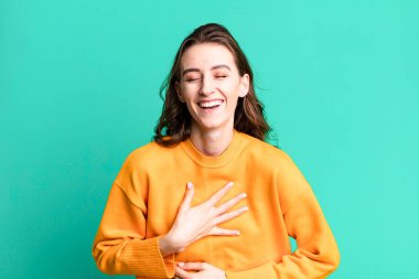 Genç ve güzel bir kadın komik bir şakaya yüksek sesle gülüyor.