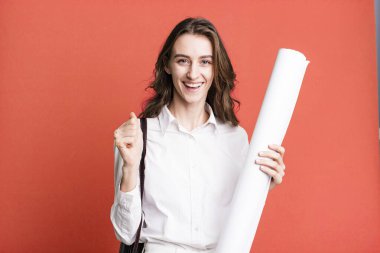 young pretty woman feeling shocked,laughing and celebrating success. architect concept