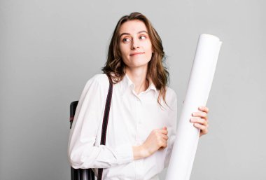 young pretty woman shrugging, feeling confused and uncertain. architect concept