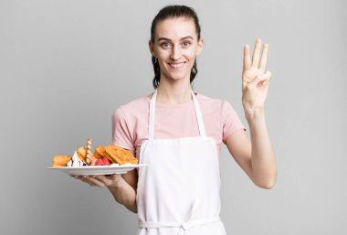 Genç, güzel bir bayan gülümsüyor ve arkadaş canlısı görünüyor, üç numarayı gösteriyor. Waffle konsepti
