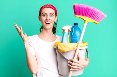 young pretty woman feeling happy and astonished at something unbelievable. housekeeper concept