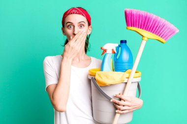 young pretty woman covering mouth with hands with a shocked. housekeeper concept