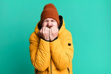 Uzun sakallı, kızıl saçlı, şapkalı ve ceketli havalı bir adam. Soğuk ve kış kavramı