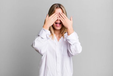 Sarışın, güzel bir kadın gülümsüyor ve mutlu hissediyor, iki eliyle gözlerini kapatıyor ve inanılmaz bir sürpriz bekliyor.